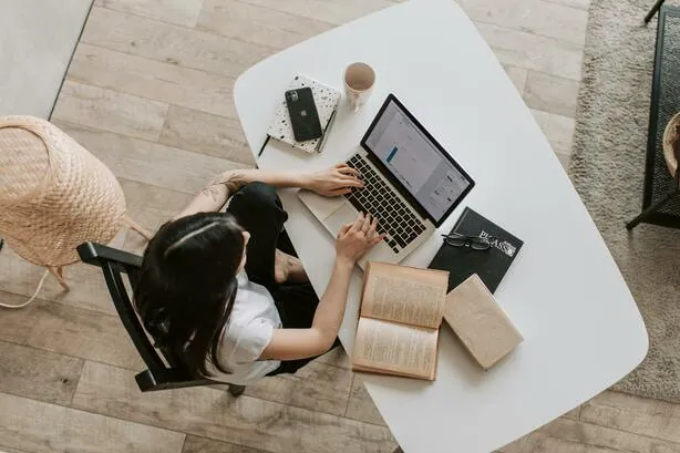A woman researching homes on a laptop in her living room
